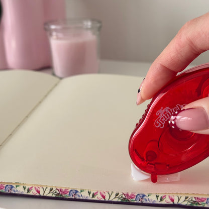 Glue tape roller photographed as a physical product with sliding cap